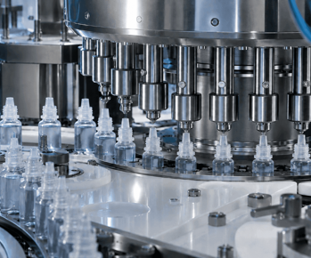 Ophthalmic bottle filling machine in an industrial pharmaceutical manufacturing facility. Ophthalmic bottle filling machine in an industrial pharmaceutical manufacturing facility.